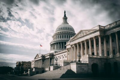 US Capitol building at dramatic angle under stormy sky