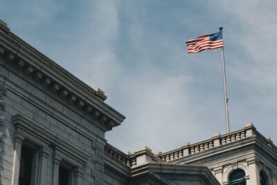 American flag flying atop a neoclassical stone government building